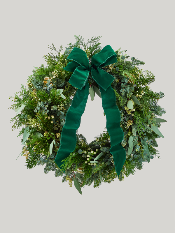Green wreath with a large green bow on a light gray background