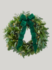 Green wreath with a large green bow on a light gray background